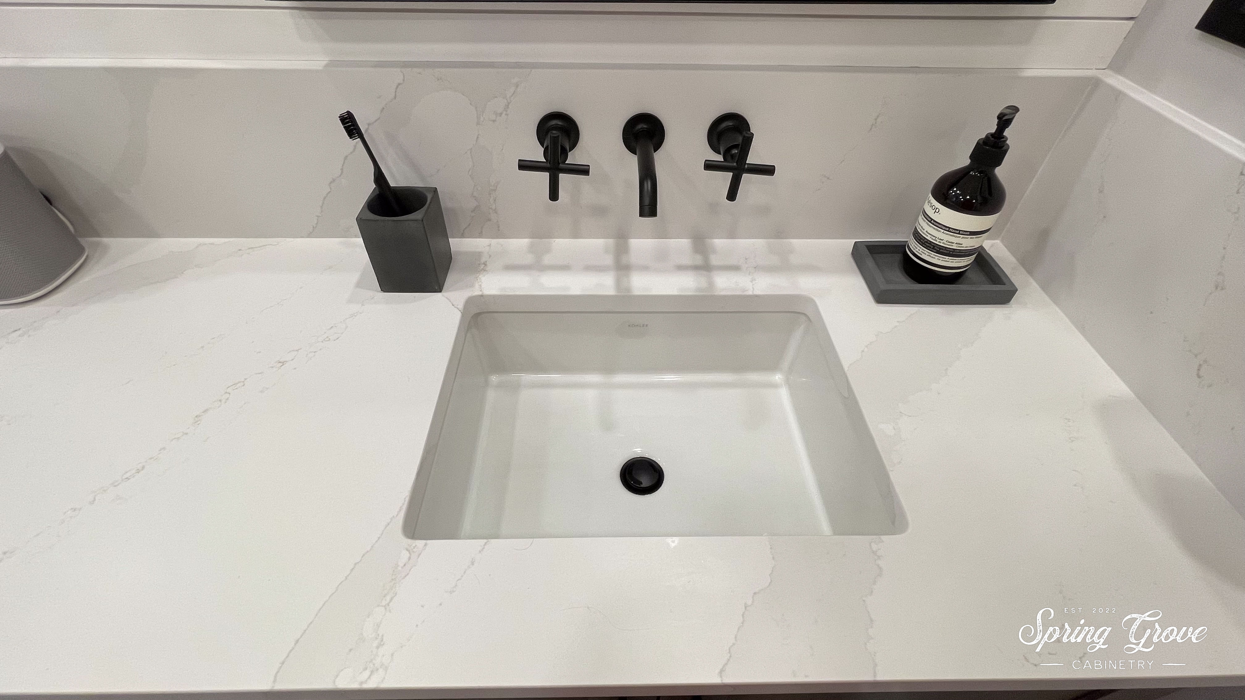 Wall mounted faucet with a tall backsplash.