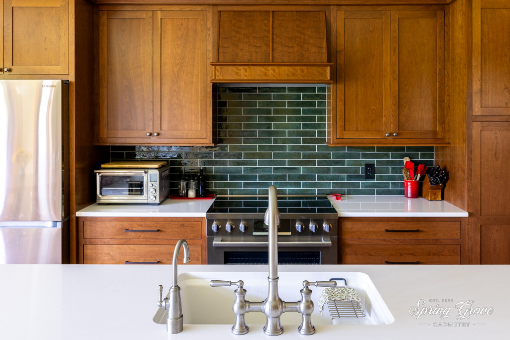 The island features a farm style sink with Kohler faucets.