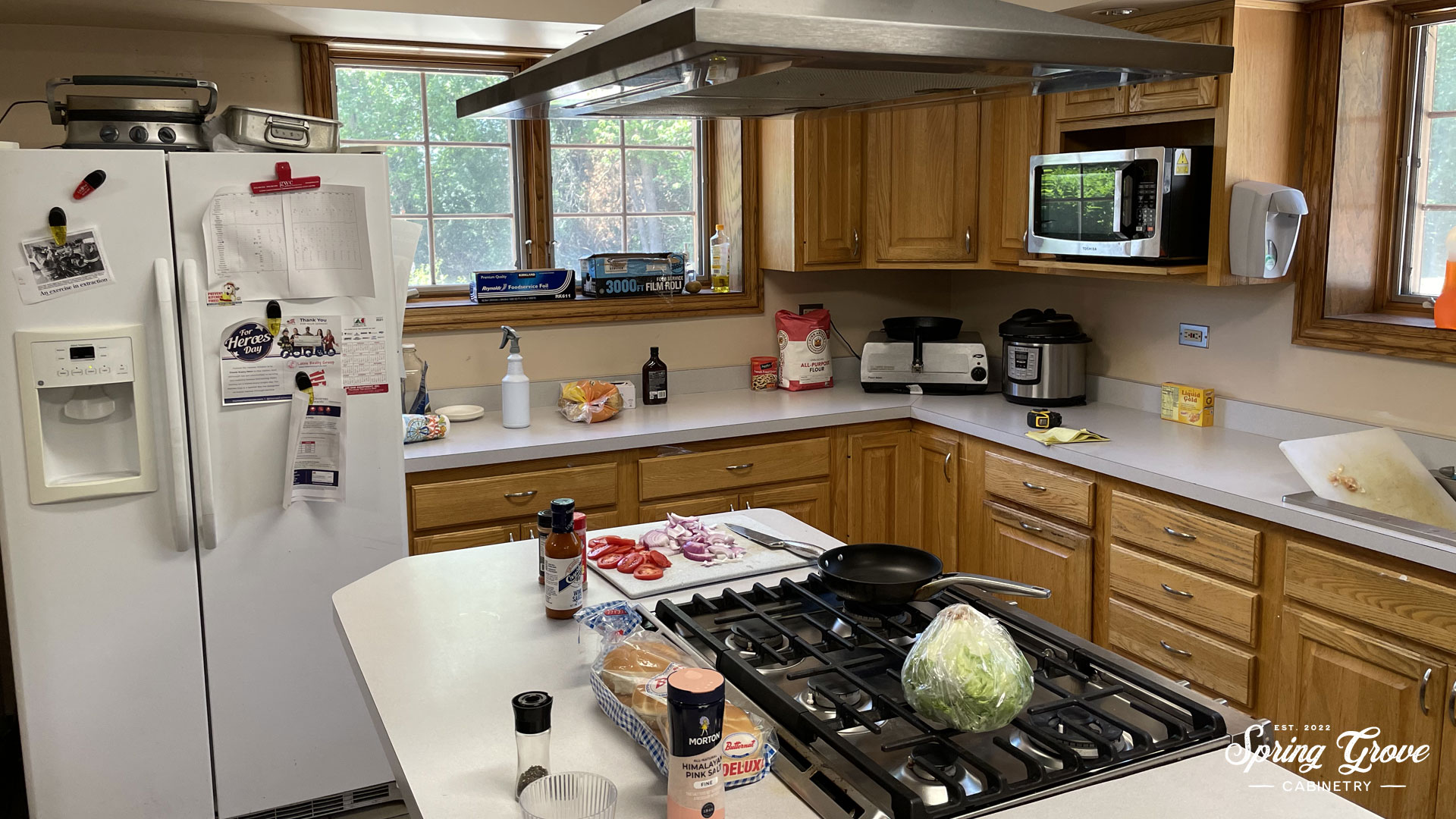 Before kitchen with a single refrigerator and small island.