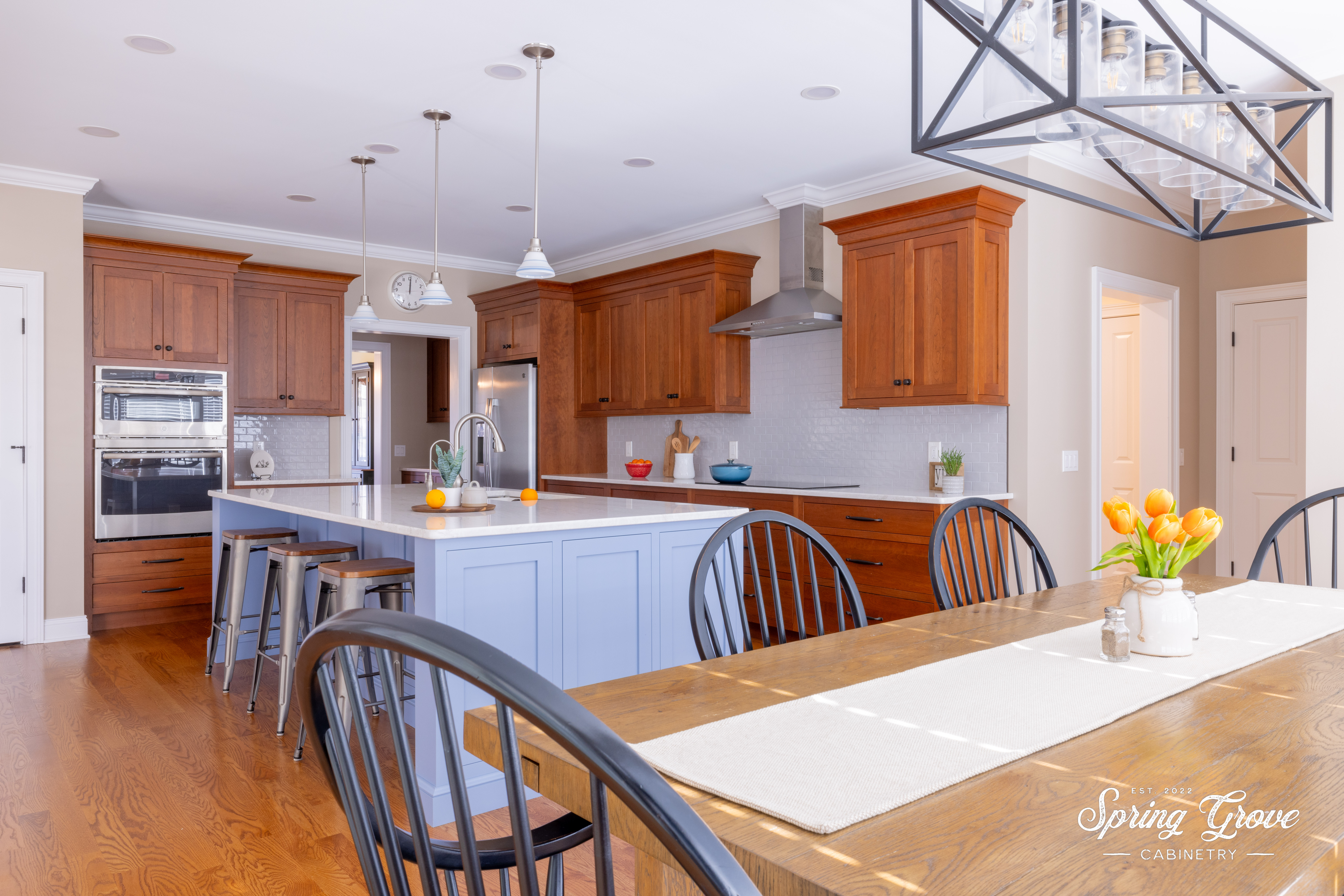 The kitchen features a large island with a grand harvest table for entertaining.